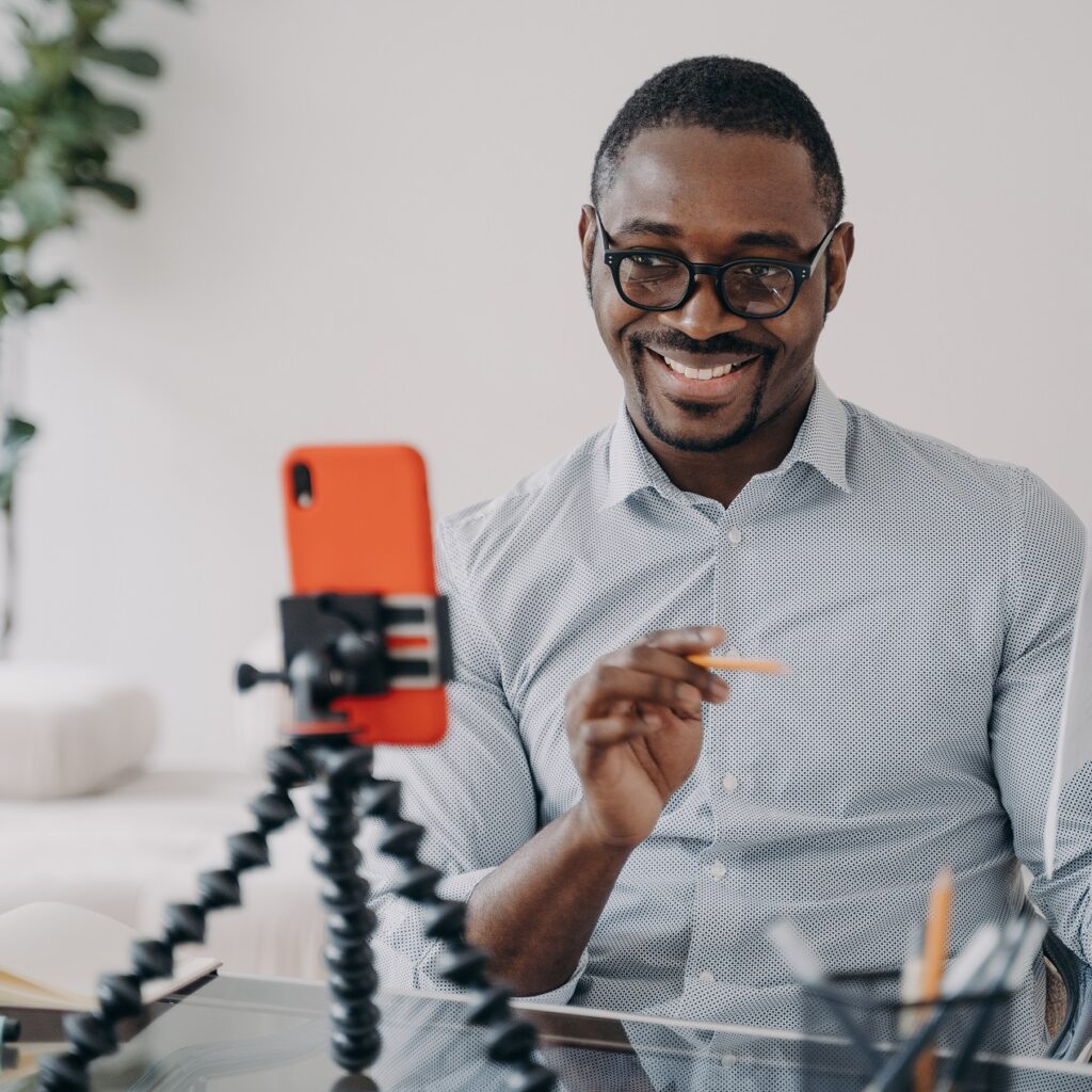 smiling african american businessman presenting business data online by video call, using smartphone